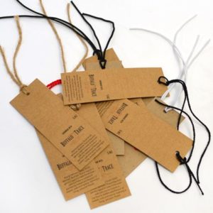 Brown Kraft hang tags crafted from eco-friendly material, featuring natural texture and minimalist design, with sturdy eyelets for durable hanging on products, ideal for branding with a focus on sustainability and simplicity in retail.